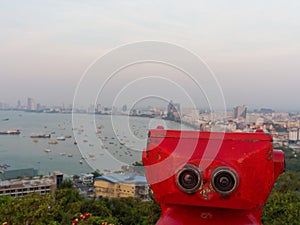 Red binocular on Pattaya beach showing explore and discover new place in tourism industry