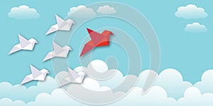 Red bird with white birds and cloud on blue sky background. Leader or leadership, teamwork and success concept.