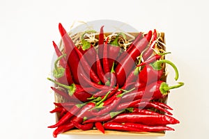 Red bitter chili peppers in a craft box on a white blank background for text