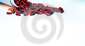 Red-black antibiotic capsule pills spread out of plastic drug bottle on white background. Antibiotic drug resistance.