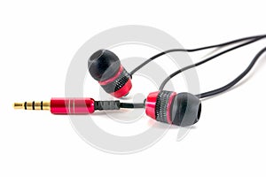 Red and black audio cable and earphone isolated on white background