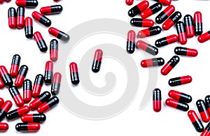 Red-black capsule pills spread on white background. Antibiotic drug use with reasonable. Pharmaceutical industry. Pharmacy