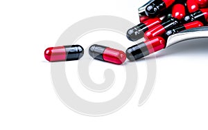 Red and black capsule pills on stainless steel drug tray. Antibiotics drug resistance. Global healthcare. Antimicrobial capsule