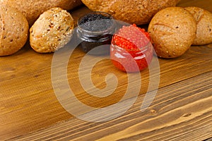 Red and black caviar in a jar with bread