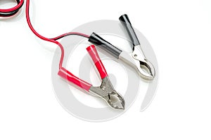 Red and black clip-on connecting and charging cable for 12 Volt battery isolated on white background