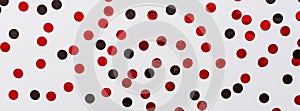 Red and black confetti on white background. Festive backdrop for your projects. Flat lay, top view, overhead, mockup, template.