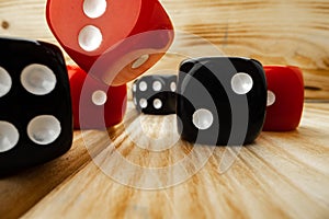 Red and black dice cubes on wooden background