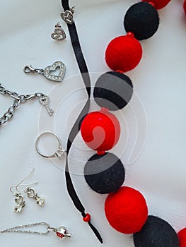 Red and black felt balls. Woolen beads and silver jewelry.