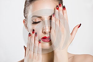 Red and black gradient nails and lips combination set. Beautiful young woman covering her eye with her hand, nude makeup false