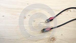 red black HDMI cable with wooden background