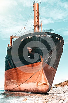 A red-and-black ship aground. Close-up of the bow of the ship