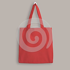 Red blank cotton eco tote bag, design mockup. Shopping bag hanging on wall