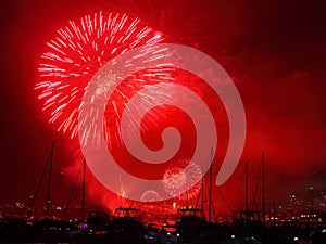 Red blast fireworks over harbor landscape night scene