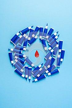 Red blood drop in circle of lancets on a blue background, World diabetes day