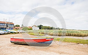 Red and blue boat on the shore at Brancaster Staithe