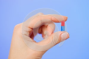 Red and blue bolus (capsule) in doctor hand