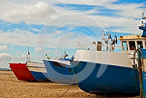 Red and blue fishing boats on the seashore