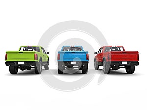 Red, blue, green pick-up trucks - rear view