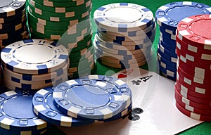 Red, blue, green, white and black poker chips pile and aces