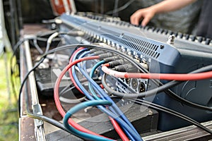 Red and blue microphone cables connected in a sound mixing console at the soundcheck for an open air music festival, selected