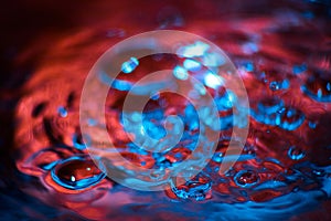 Red and blue neon background from water surface with bubbles