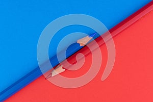 A red and blue pencil separates the red and blue background.