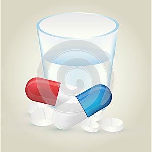 Red and blue pillules with white pills and glass of water on lig