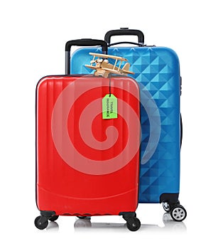 Red and blue suitcases with TRAVEL INSURANCE label on white