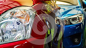 Red and blue SUV car parked on concrete parking lot of the hotel, home, or apartment. Automotive industry. Electric or hybrid car