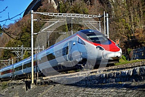 Red blue train in motion alps mountains. High speed mountain train arrives at Switzerland