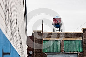 Red and Blue Water Tower On Top of Brick Building