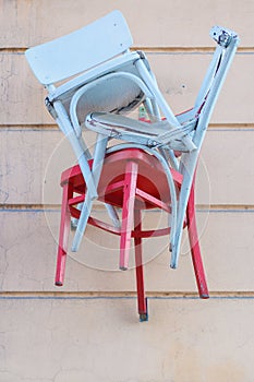 Red and blue wooden chairs on a wall