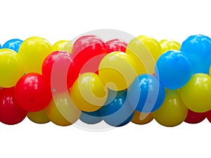 Red, blue and yellow celebration balloons in stack isolated