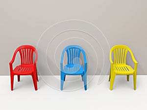 Red, blue and yellow normal plastic chairs in white room