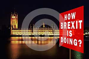 Red board with phrase & x27;How BREXIT is Doing?& x27;. Brexit Concept with parliament in background at night. London, UK
