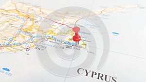 A red board pin stuck in Ayia Napa on a map of Cyprus