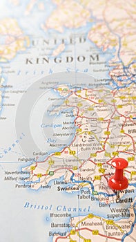 A red board pin stuck into Cardiff on a map of Wales