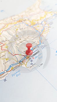 A red board pin stuck in Limassol on a map of Cyprus portrait
