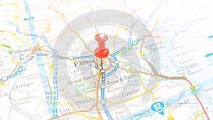 A red board pin stuck in Padova on a map of Italy photo