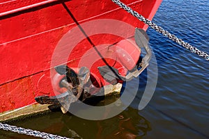 A red boat with a black anchor on it