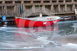 Red boat in frozen Copenhagen canal - winter season