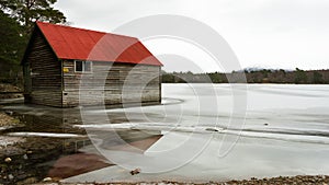 Red boat house on a frozen lake