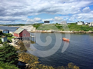 Red boat, houses, green grass, summer in Peggy's Cove, Canada