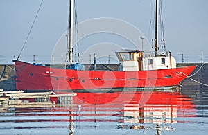 Red boat with white wheelhouse in Harbor. photo