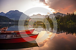 Red boats on Lake Strbske pleso. Morning view of the High Tatras National Park, Slovakia, Europe.