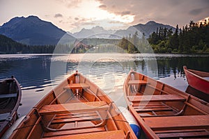 Red boats on Lake Strbske pleso. Morning view of the High Tatras National Park, Slovakia, Europe.