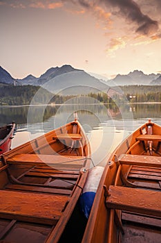 Red boats on Lake Strbske pleso. Morning view of the High Tatras National Park, Slovakia, Europe.