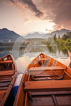 Red boats on Lake Strbske pleso. Morning view of the High Tatras National Park, Slovakia, Europe.