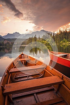 Red boats on Lake Strbske pleso. Morning view of the High Tatras National Park, Slovakia, Europe.