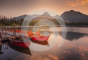 Červené lodě na jezeře Štrbské pleso. Ranní pohled na národní park Vysoké Tatry, Slovensko, Evropa.